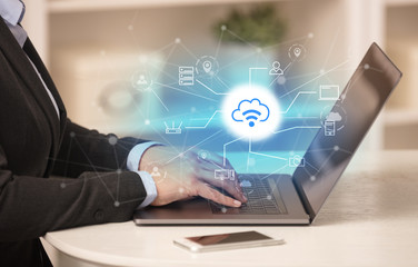 Business woman in homey environment using laptop with  online storage and cloud technology concept
