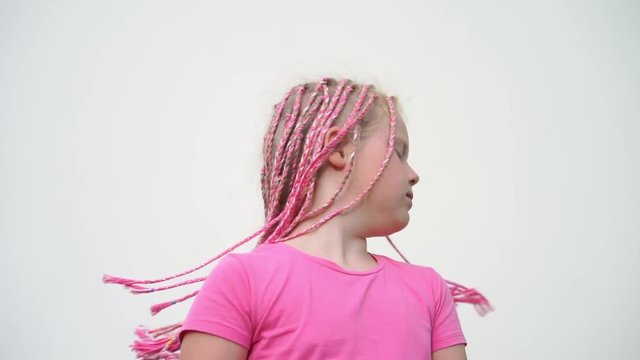 the beauty of slow motion - portrait of a beautiful light-skinned little girl of a non-standard modern appearance - with pink African plaits of zizi