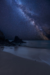 Vibrant Milky Way composite image over landscape of Barafundle Bay on Pembrokeshire Coast in Wales