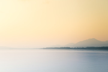 A beautiful, calm morning landscape of lake and mountains in the distance. Colorful summer scenery with mountain lake in dawn. Tatra mountains in Slovakia, Europe.