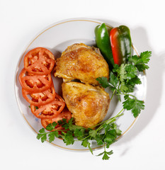 Fried chicken with vegetables on a round plate on a white background.