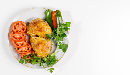 Fried chicken with vegetables on a round plate on a white background.