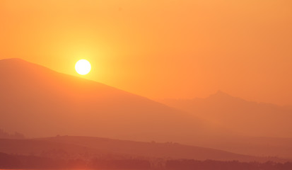 A beautiful sunrise over the lake with mountains in distance. Morning landscape in warm tones. Tatra mountains in Slovakia, Europe.