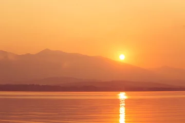 Fototapete Rund Tiefes Orange A beautiful sunrise over the lake with mountains in distance. Morning landscape in warm tones. Tatra mountains in Slovakia, Europe.  © dachux21