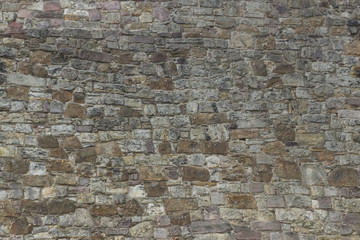 Hintergrund von Steinwand mit kleinen Steinen in Grau und Braun