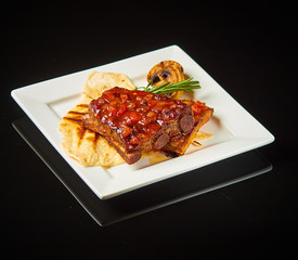 Pork ribs on a white plate with a black photo 