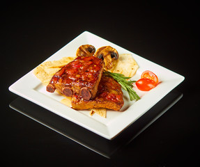 Pork ribs on a white plate with a black photo 