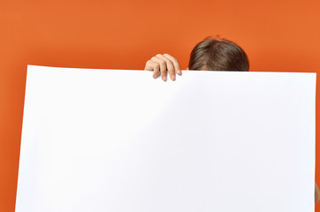 man holds his hand a white sheet of paper on a red background