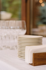 Fototapeta na wymiar Glasses and white plates on a table at restaurant.