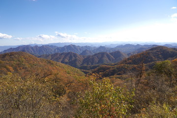 晴天の秋空と紅葉に染まる山々