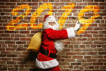 Obraz na płótnie Canvas Astonished Santa Claus writing on a brick wall painted.