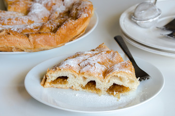 Piece of Ensaimada, coil-shaped flaky pastry from Mallorca, Balearic Islands. This is one of popular pastries in Spain eating at breakfast, snack time and dessert