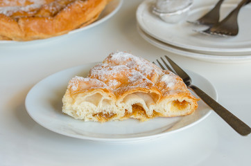 Piece of Ensaimada, coil-shaped flaky pastry from Mallorca, Balearic Islands. This is one of popular pastries in Spain eating at breakfast, snack time and dessert