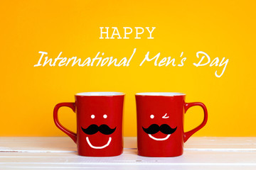 International men's day background with two red coffee mugs with a smiling whiskered faces on a...