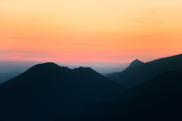 Fototapeta premium Piękna, kolorowa, abstrakcyjna górska sceneria w wschodzie słońca. Minimalistyczny krajobraz gór rano w niebieskich kolorach. Tatry na Słowacji, w Europie.