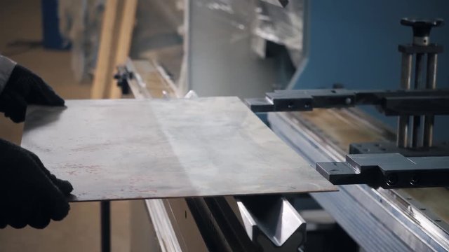 Tool and bending equipment for sheet metal. manufacture workshop. Workers adjusts the machine in the warehouse. the production of ventilation and gutters.