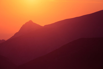 A beautiful, colorful sunrise sceney in mountains in purlpe tone. Abstract, minimalist landscape in Tatra mountains. Color gradients. Tatra mountains in Slovakia, Europe.