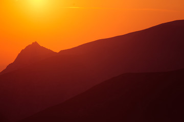A beautiful minimalist landscape during the sunrise over mountains in warm tones. Abstract, colorful scenery of mountains in morning. Tatra mountains in Slovakia, Europe.