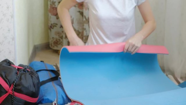 A Woman Tourist Collects Things In A Backpack In The Kitchen Of The House And Prepares For A Trip