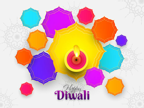 Top view of illuminated oil lamp with colorful abstract design on white background for Indian Festival Diwali celebration. Can be used as greeting card design.