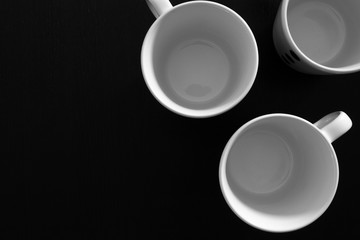 Empty white cups on black wooden table