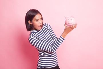 Young Asian woman with a pig coin bank.