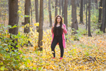 Autumn, nature and people concept - Portrait of plus size woman in pink jacket in park