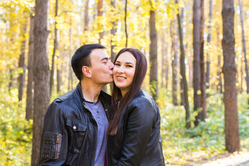 Fototapeta premium Love, relationship, family and people concept - smiling couple hugging in autumn park