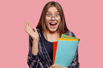 Photo of amazed Caucasian woman keeps palm near face, exclaims with positiveness, happy to hear...