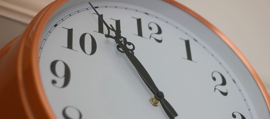 Fototapeta na wymiar Bronze wall clock showing 10.54am