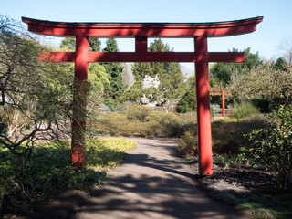 Roter Torbogen in asiatischer Form in front eines Parkes