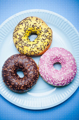 three glazed donuts on a plate