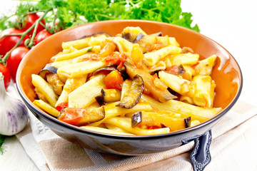 Pasta penne with eggplant and tomatoes on table