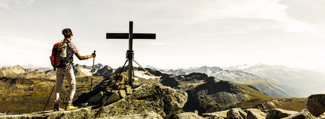 Bergsteigerin am Gipfelkreuz