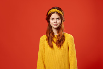 beautiful woman in a sweater on a red background