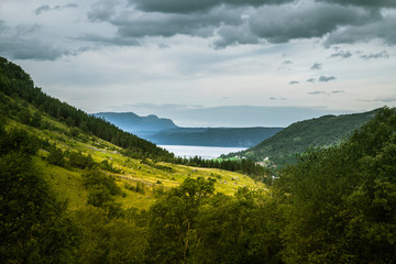 A beautiful autumn landscape of mountains in Folgefonna National park with fjord far in the distance. Fall scenery of southern Norway, Autumn colors in overcast day.