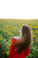 Naklejka na ściany i meble Beautiful joyful woman in sunflower field