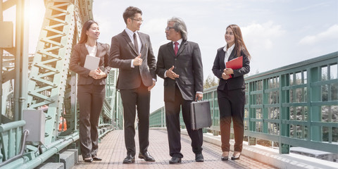 Merger and acquisition.Beautiful business maneger woman and  man of partnership smiling and talking about success work.Business people holding tablet and paperwork in black suite.