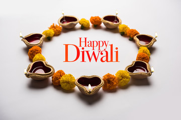 Happy Diwali Greeting Card made using sweets, or fire crackers or Diya or flowers, selective focus