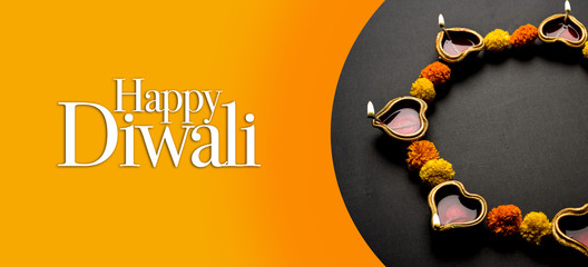 Happy Diwali Greeting Card made using sweets, or fire crackers or Diya or flowers, selective focus