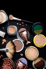 Fototapeta na wymiar luxery Set of bronze powder with makeup brushes on black background