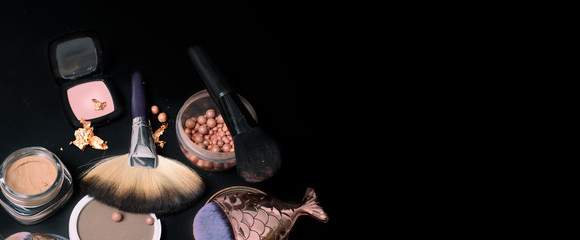 luxery Set of bronze powder with makeup brushes on black background