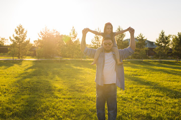 Fatherhood, family and children concept - Father and daughter having fun and playing in nature.