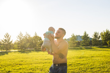 Happy father holding baby son, throwing baby in air. Concept of happy family, father's day and child.