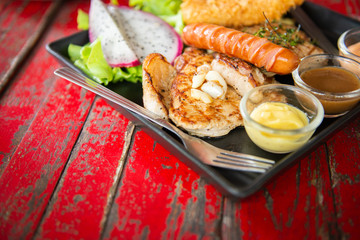 top view of mix steak with and fresh green herb salad and dragon fruit on vintage wooden table