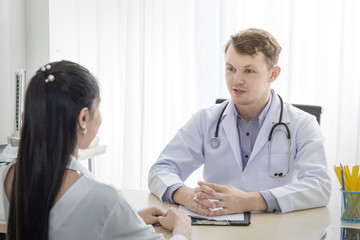 Medical professionals caucasian man reassuring and talking with young woman stress patient.Close up and copy space.