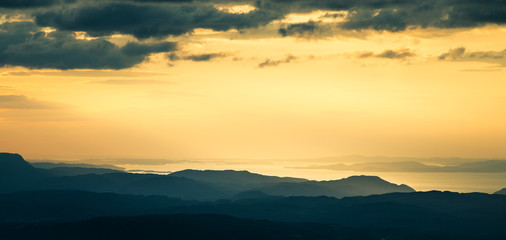 A magnificent sunset scenery over the fjords in Norway. A beautiful autumn landscape in Folgefonna national park. Dramatic sky and mountains.