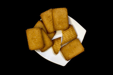 Brown and dark biscuits in plate of white base