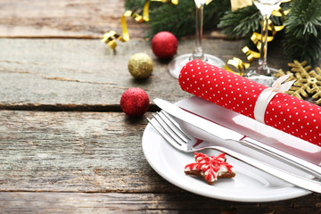 Kitchen cutlery with plate and christmas decorations on wooden table
