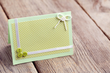 Green greeting card on grey wooden table
